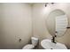 Small bathroom with toilet and sink, and an oval mirror at 101 Runaway Field Ave, Nokomis, FL 34275