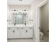 Modern bathroom with double vanity, white cabinets, and a walk-in shower at 101 Runaway Field Ave, Nokomis, FL 34275