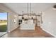 Open concept dining room with chandelier and view to kitchen and backyard at 101 Runaway Field Ave, Nokomis, FL 34275