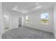 Spacious bedroom with carpet, two windows, and access to bathroom at 9572 Vibrant Lane, Venice, FL 34292