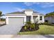 One-story home with gray garage door, landscaping, and paver driveway at 9572 Vibrant Lane, Venice, FL 34292
