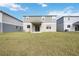 Newly constructed home with a covered patio and grassy backyard at 37488 Williamette Way, Zephyrhills, FL 33540