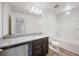 Modern bathroom with granite countertop, dark brown vanity, and a bathtub at 37488 Williamette Way, Zephyrhills, FL 33540