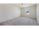 Well-lit bedroom featuring grey carpet and large window at 37488 Williamette Way, Zephyrhills, FL 33540