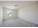 Spacious bedroom with grey carpet and a window at 37488 Williamette Way, Zephyrhills, FL 33540