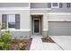 Front entrance with dark gray door and walkway at 37488 Williamette Way, Zephyrhills, FL 33540