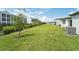 Large backyard with green grass and neighboring buildings at 396 Lazy Shore Dr, Nokomis, FL 34275