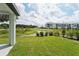 View of the backyard with pond and neighboring building at 396 Lazy Shore Dr, Nokomis, FL 34275