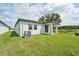 Home's backyard features a covered patio and grassy lawn at 396 Lazy Shore Dr, Nokomis, FL 34275