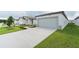 House exterior showcasing a grey garage door and landscaped lawn at 428 Lazy Shore Dr, Nokomis, FL 34275