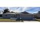 Gray house with solar panels, landscaped yard, and attached garage at 7524 Oakshire Dr, Port Richey, FL 34668