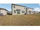 Image shows the backyard and back of the home with sliding glass doors and an adjacent home at 14009 Crutchfield Ct, Parrish, FL 34219