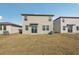 View of the backyard with grass and back exterior of the home with sliding glass doors at 14009 Crutchfield Ct, Parrish, FL 34219