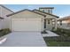 Attractive single-Gathering home featuring a two-car garage, modern architectural details, and fresh landscaping at 14009 Crutchfield Ct, Parrish, FL 34219