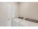 Laundry room area with side-by-side white washer and dryer at 14009 Crutchfield Ct, Parrish, FL 34219