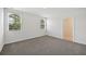 Bright bedroom with two windows, neutral carpeting, and access to a bathroom at 156 Lazy Shore Dr, Nokomis, FL 34275