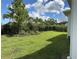 Landscaped backyard with a lush lawn and mature trees at 5520 Limelight Dr, Apollo Beach, FL 33572