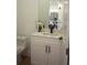 Single vanity bathroom with white cabinets and toilet at 23335 Mac Dougall Ave, Port Charlotte, FL 33980