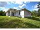 Single-story home exterior with covered patio and grassy yard at 23335 Mac Dougall Ave, Port Charlotte, FL 33980