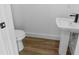Small bathroom with toilet and pedestal sink at 10071 Kingsville Dr, Port Charlotte, FL 33981