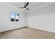 Bright bedroom featuring wood-look floors and a ceiling fan at 10071 Kingsville Dr, Port Charlotte, FL 33981