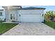 Modern home with white garage door and a paver driveway at 10071 Kingsville Dr, Port Charlotte, FL 33981
