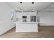 Modern white kitchen with island, stainless steel appliances, and hardwood floors at 10071 Kingsville Dr, Port Charlotte, FL 33981