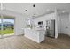 Modern white kitchen with island, stainless steel appliances, and hardwood floors at 10071 Kingsville Dr, Port Charlotte, FL 33981