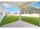 Covered back porch overlooking a lush green yard and white fence at 37501 Williamette Way, Zephyrhills, FL 33540