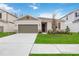 Newly constructed home with a two-car garage and well-manicured lawn at 37508 Williamette Way, Zephyrhills, FL 33540