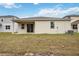 Tan house exterior with covered patio and grassy backyard at 37508 Williamette Way, Zephyrhills, FL 33540