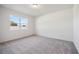 Bright bedroom with grey carpet and a window offering natural light at 37513 Williamette Way, Zephyrhills, FL 33540