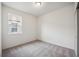 Simple bedroom with grey carpet and window at 37513 Williamette Way, Zephyrhills, FL 33540