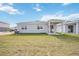 Rear view of a single-story house with a covered patio and fenced backyard at 37513 Williamette Way, Zephyrhills, FL 33540