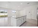 An open, bright kitchen island with granite countertops, white cabinets, and recessed lighting at 37513 Williamette Way, Zephyrhills, FL 33540