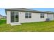 Home exterior showcasing a grassy backyard and sliding glass door at 7760 Gilchrist Springs Dr, Parrish, FL 34219