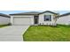 Single-story home with a white exterior, two-car garage, and landscaped lawn at 7760 Gilchrist Springs Dr, Parrish, FL 34219