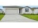 Single story home with white exterior, two-car garage, and landscaped lawn at 7760 Gilchrist Springs Dr, Parrish, FL 34219