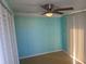 Light teal bedroom with a ceiling fan and sliding door at 14914 Capri Ln, Hudson, FL 34667