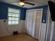 Blue bedroom with a ceiling fan and built-in closet at 14914 Capri Ln, Hudson, FL 34667