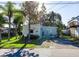 Cute light blue home with a well-maintained lawn and mature trees at 14914 Capri Ln, Hudson, FL 34667