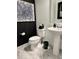 Stylish bathroom with pedestal sink, modern toilet, and abstract art at 8394 Olive Brook Dr, Wesley Chapel, FL 33545