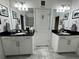 Double vanity bathroom with black countertops and white cabinets at 8394 Olive Brook Dr, Wesley Chapel, FL 33545