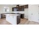 L-shaped kitchen with island, dark cabinets, and white countertops at 37545 Mackenzie Dr, Zephyrhills, FL 33540