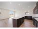 Open kitchen with island, dark cabinets, and view to backyard at 37545 Mackenzie Dr, Zephyrhills, FL 33540
