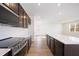 Modern kitchen featuring dark brown cabinets, stainless steel appliances, and a large island at 37545 Mackenzie Dr, Zephyrhills, FL 33540