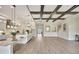 Open kitchen with white countertops, an island, ceiling beams, and modern lighting fixtures at 11146 Rustic Timber Loop, San Antonio, FL 33576