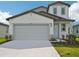 Charming two-story home with a two-car garage, light blue door, and well-maintained landscaping at 14045 Crutchfield Ct, Parrish, FL 34219