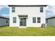Rear view of house, showcasing backyard and sliding glass door at 14045 Crutchfield Ct, Parrish, FL 34219
