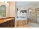 Main bathroom with soaking tub, shower, and granite countertop at 11909 Mandevilla Ct, Tampa, FL 33626